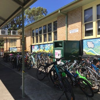 A bike rack at school filled with student bikes.