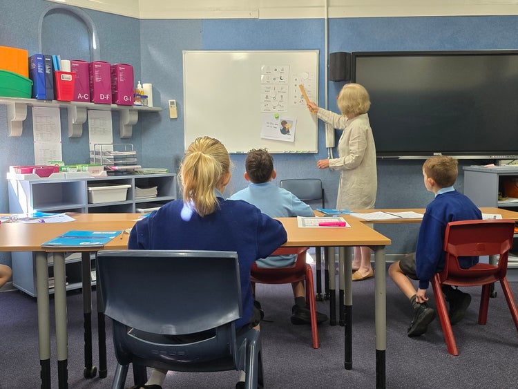 Teacher in class teaching a small group of children.